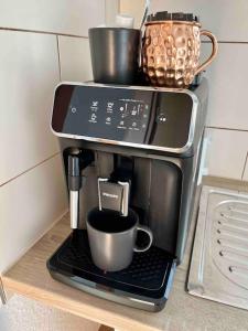 a coffee maker with a coffee cup on a shelf at Stadtmitte im Zentrum von Itzehoe aber ruhig in Itzehoe