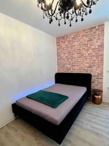 een bed in een kamer met een bakstenen muur bij Stadtmitte im Zentrum von Itzehoe aber ruhig in Itzehoe