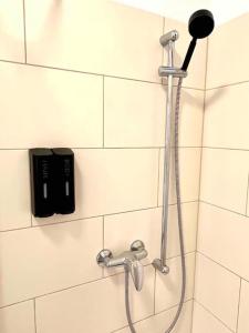 a shower in a bathroom with a phone on the wall at Stadtmitte im Zentrum von Itzehoe aber ruhig in Itzehoe