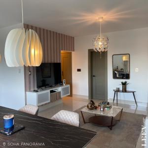 a living room with two chandeliers and a table at Soha panorama- A14- 2 dormitorios in Santiago de los Caballeros