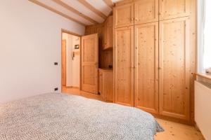 a bedroom with wooden cabinets and a bed in a room at Casa Serena in San Candido