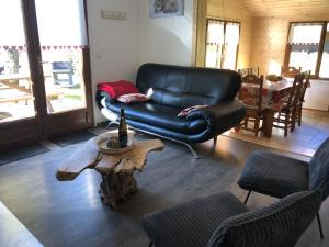 a living room with a leather chair and a coffee table at Chalet CHLOE - jusque 6 pers - Xonrupt Longemer in Xonrupt-Longemer