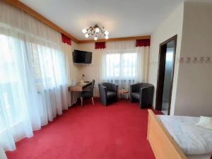 una habitación de hotel con suelo de moqueta roja y 1 dormitorio en Landhotel Neuhof en Zenting