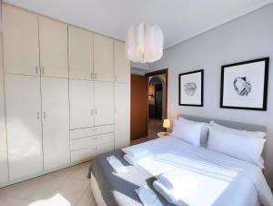 a bedroom with a bed with white cabinets and a chandelier at Nefelis C2 by Verde Apartments in Athens