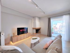 a living room with a couch and a tv at Nefelis C2 by Verde Apartments in Athens