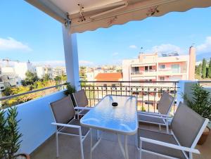 a blue table and chairs on a balcony with a view at Nefelis C2 by Verde Apartments in Athens