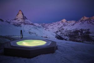 a bath tub in front of a snow covered mountain at Riffelhaus 1853 in Zermatt