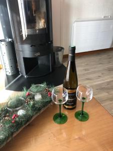 a bottle of wine and two wine glasses on a table at Chalet O FIL DE L EAU , jusque 6 pers , à XONRUPT LONGEMER in Xonrupt-Longemer