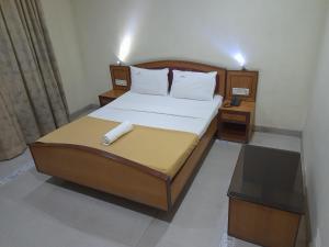 Un dormitorio con una cama y un teléfono. en DP OBEROI RESIDENCY, en Ernakulam