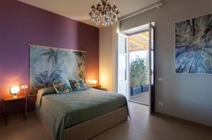 1 dormitorio con 1 cama con una pintura en la pared en Frangimare La Segreta, en Malfa
