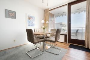 ein Esszimmer mit einem Tisch und Stühlen sowie einem Balkon in der Unterkunft Haus Meeresblick Wohnung 80 in Kellenhusen