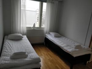 two beds in a room with a window at Lapinkatu apartments in Rovaniemi