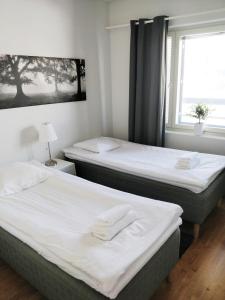 two beds in a room with a window at Lapinkatu apartments in Rovaniemi