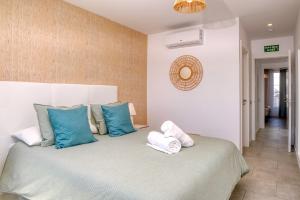 Schlafzimmer mit einem Bett mit blauen und weißen Kissen in der Unterkunft Gold SandSuperior Dúplex Vivienda Vacacional in Playa Blanca