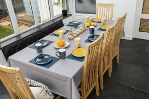 a dining room table with blue and yellow dishes on it at CROYDE PEBBLES 4 Bedrooms in Croyde