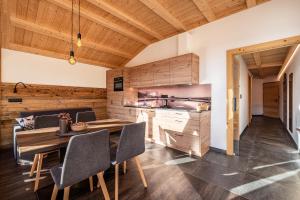 cocina y comedor con mesa de madera y sillas en Zu Grof Morgenrot, en Castelrotto