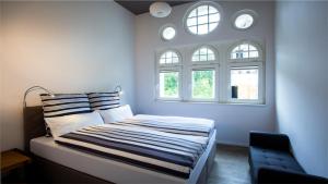 a bedroom with a bed and two windows at Parkresidenz Lychen, Ferienwohnung 8 in Lychen