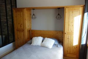 um quarto com uma cama com duas almofadas brancas em Chez petit Louis- Appart centre ville jusqu'à 6 personnes em Briançon