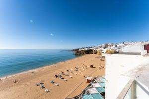 une vue sur une plage avec des parasols et l'océan dans l'établissement Casa dos Sonhos Albufeira, à Albufeira