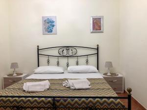 Villa Oasi Dei Sogni في لامبيدوسا: غرفة نوم بسرير كبير مع مواقف ليلتين