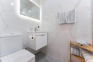 une salle de bains blanche avec toilettes et lavabo dans l'établissement Casa dos Sonhos Albufeira, à Albufeira 19 autres photos