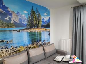 a living room with a large mural of a lake and mountains at Apartament Widok Polana Szaflarska in Nowy Targ