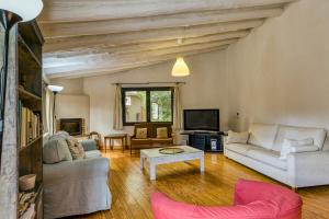 a living room with two couches and a tv at Can Lluna Rural House in Avinyonet de Puigventós