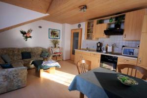 a kitchen and living room with a couch and a table at Ferienhaus Corinna in Kirchdorf im Wald