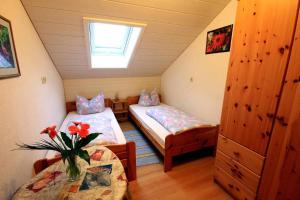 Cette petite chambre comprend 2 lits et une fenêtre. dans l'établissement Ferienhaus Corinna, à Kirchdorf im Wald