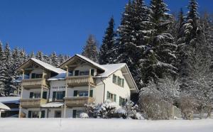 a large building with snow covered trees in front of it at Ferienhaus Corinna in Kirchdorf im Wald