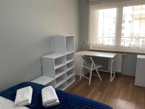 a bedroom with a bed and a desk and a window at Apartament Rezydencja Metropolis ul.Dąbrowa 15 in Bydgoszcz
