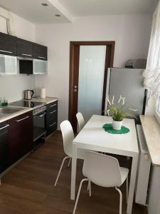 a kitchen with a white table and white chairs at Apartament Rezydencja Metropolis ul.Dąbrowa 15 in Bydgoszcz