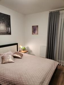 a bedroom with a bed with a white comforter at Apartament Widok Polana Szaflarska in Nowy Targ