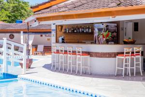 a bar on the side of a swimming pool at Ciribaí Praia Hotel in Pauba