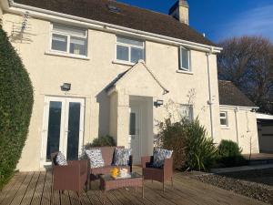 a house with chairs and a table on a deck at WOOLACOMBE OAKLEA 4 Bedrooms in Woolacombe