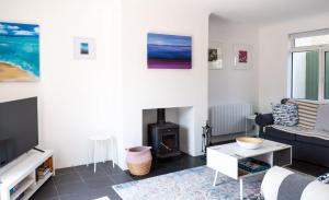 a living room with a fireplace and a couch at WOOLACOMBE OAKLEA 4 Bedrooms in Woolacombe