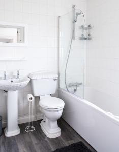 a bathroom with a toilet and a sink and a shower at WOOLACOMBE OAKLEA 4 Bedrooms in Woolacombe