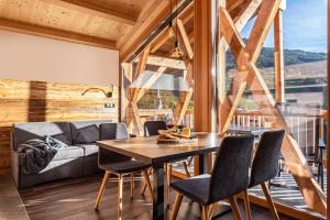 uma sala de jantar com uma mesa e cadeiras e um sofá em Zu Grof Alpenglühn em Castelrotto