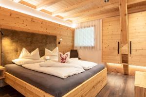 a bedroom with a large bed in a wooden room at Zu Grof Alpenglühn in Castelrotto