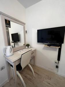 Elle comprend un bureau avec une chaise et une télévision murale. dans l'établissement Guesthouse Athos, à Kotor