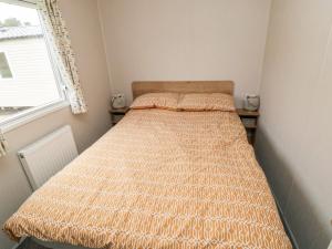 a small bedroom with a bed in a room with a window at Pines 30 in Scarborough