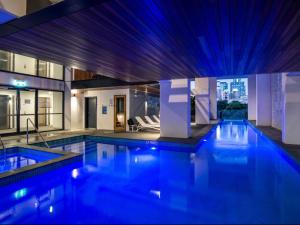 una gran piscina con luces azules en un edificio en Lovely 2 Beds Apt with City View at South Brisbane, en Brisbane