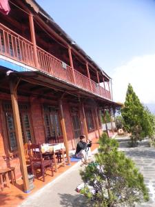 um homem sentado em frente a um edifício em Rupa View Guest house em Pokhara