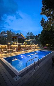 a swimming pool on a wooden deck with a table and chairs at Gigiri Lion Villas II in Nairobi