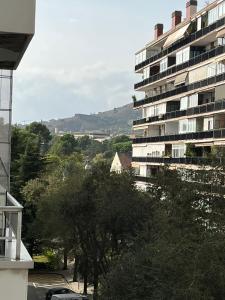 un grand immeuble d'appartements avec des arbres devant lui dans l'établissement Precioso y tranquilo apartamento zona alta Diagonal Barcelona, à Barcelone