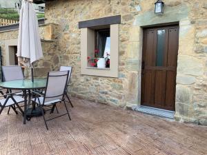 patio con mesa, sillas y puerta en Casa Rural Vivienda Vacacional L´Andolina Complejo CaleaCabo, en Biescas