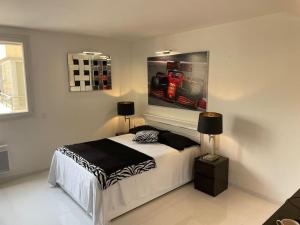 una camera da letto con un letto e un dipinto sul muro di Eider a Cannes