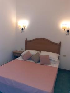 a bedroom with a large bed with two lights on the wall at RESIDENCE TERME ISOLA D'ELBA SRL in Portoferraio