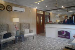 a man standing in a waiting room with a mirror at Premier Inn Grand Gulberg Lahore in Lahore