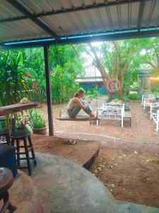 a woman sitting on the ground under a tent at Moov Inn Garden Hostel in Ko Tao